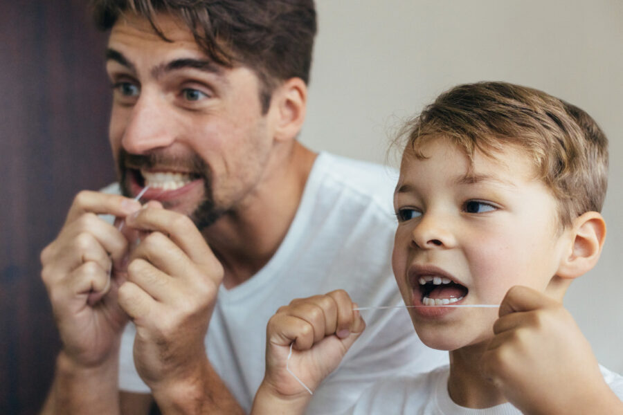 Person demonstrating how to floss correctly with Brava hidden braces